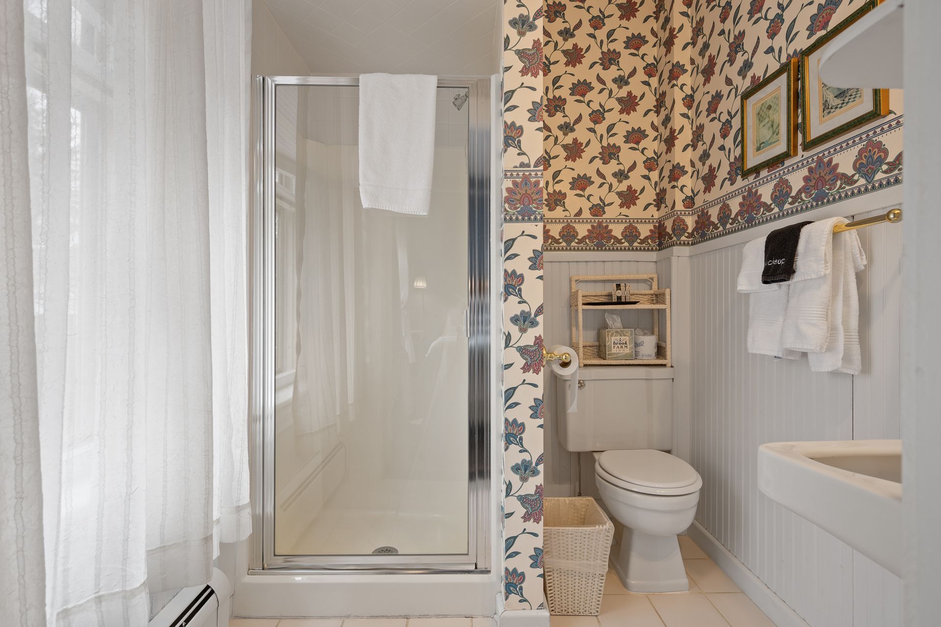A bathroom with a toilet , sink and shower.