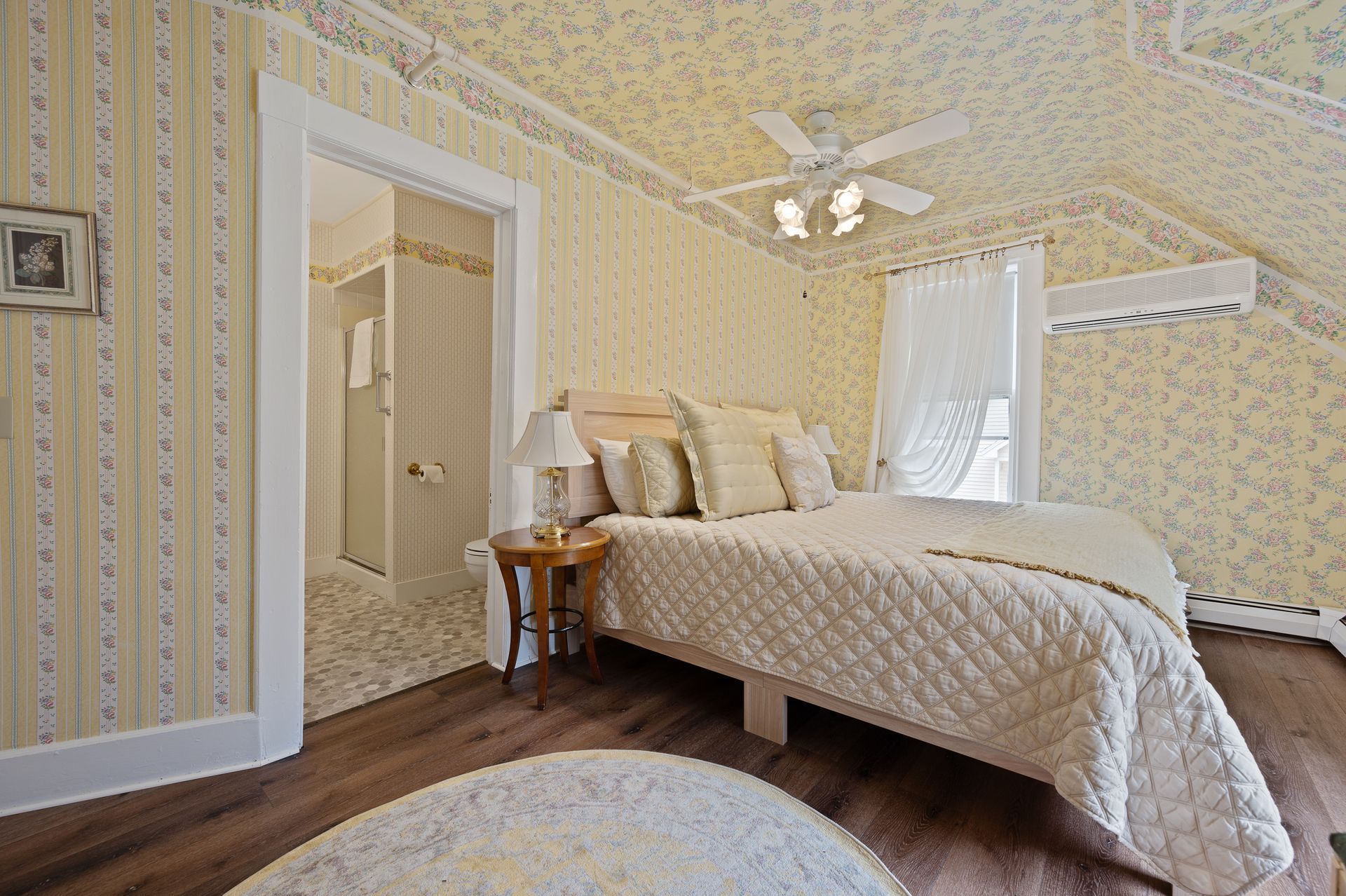 A bedroom with a bed and a ceiling fan.