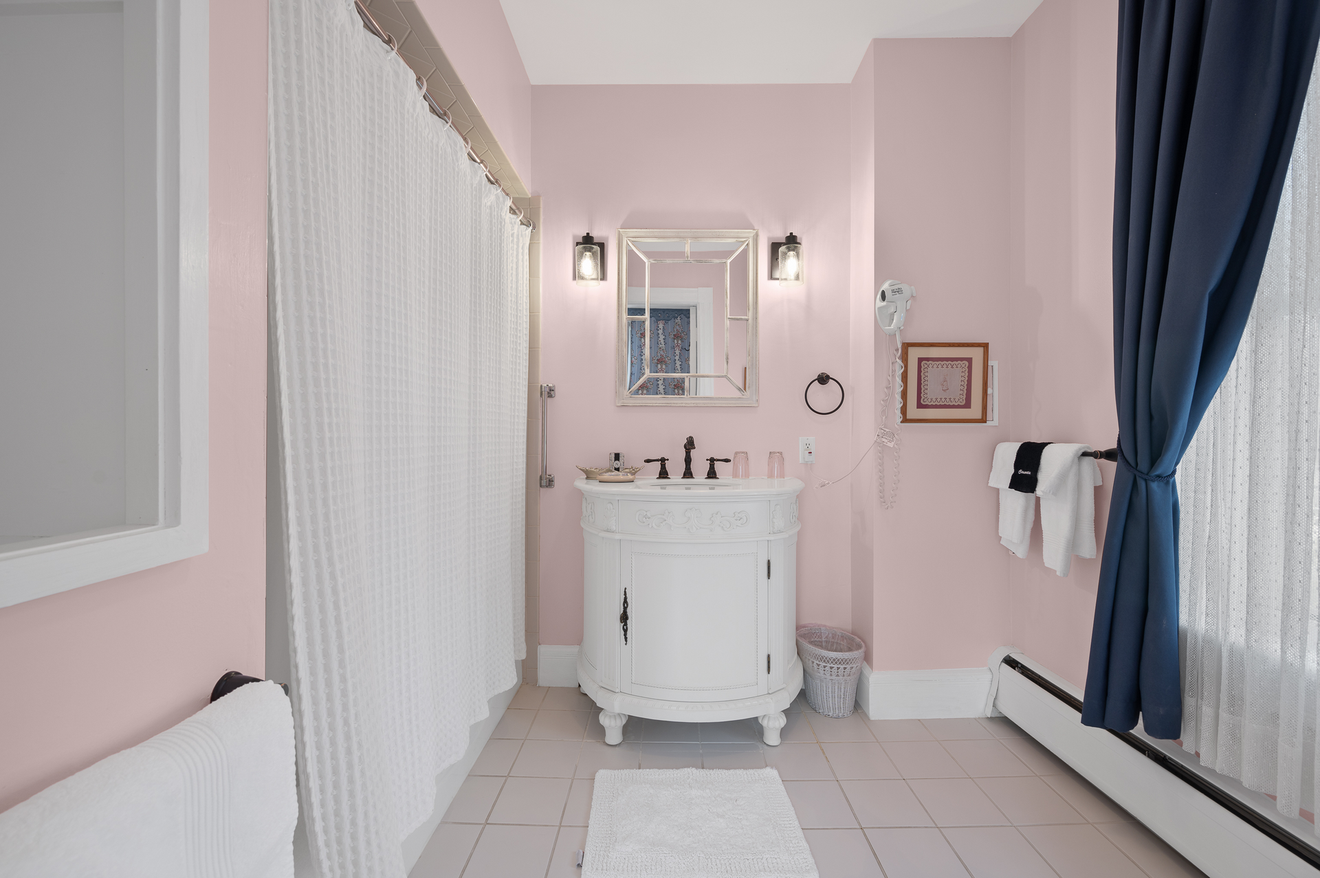 A bathroom with pink walls and a white sink