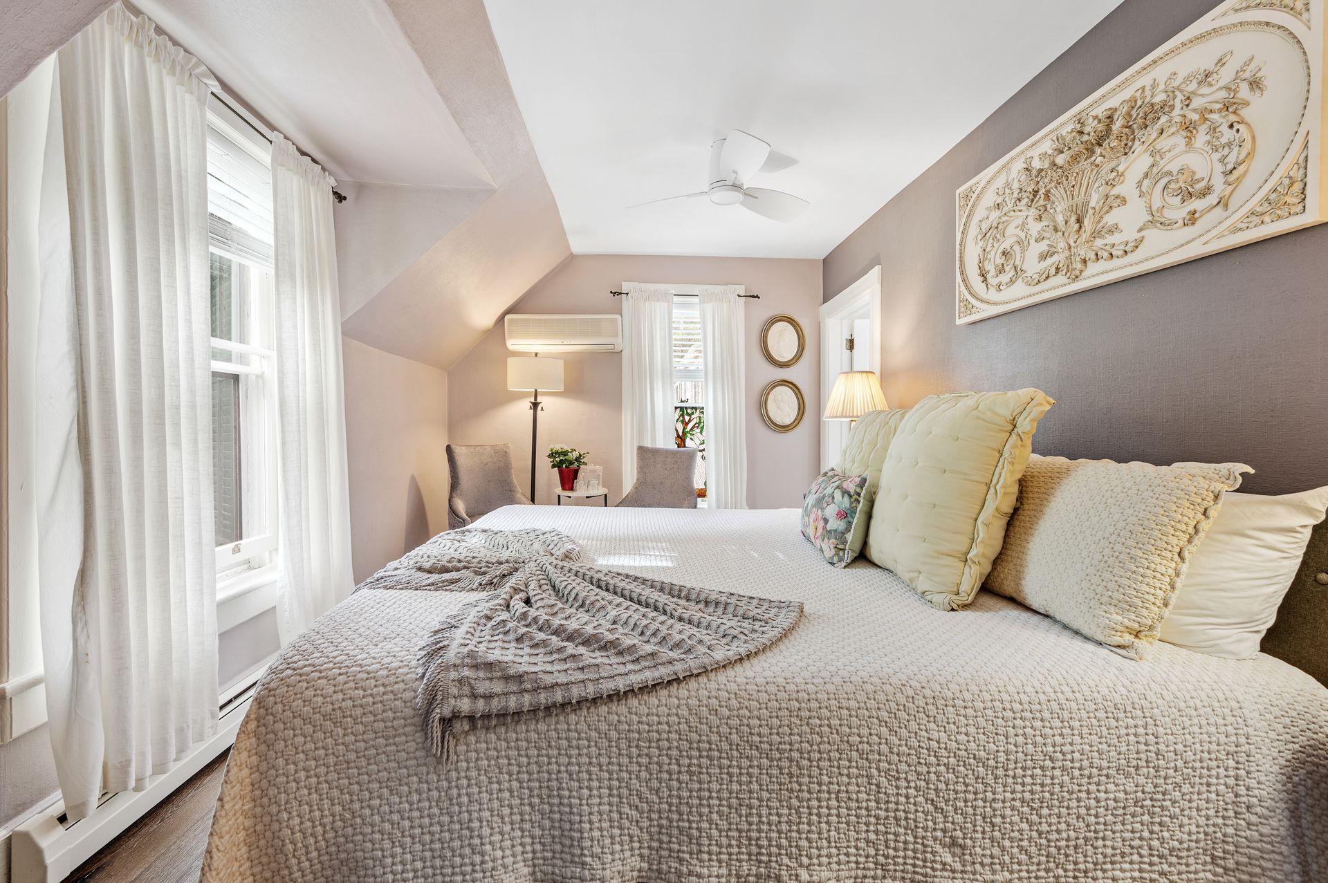 A bedroom with a large bed and a ceiling fan.