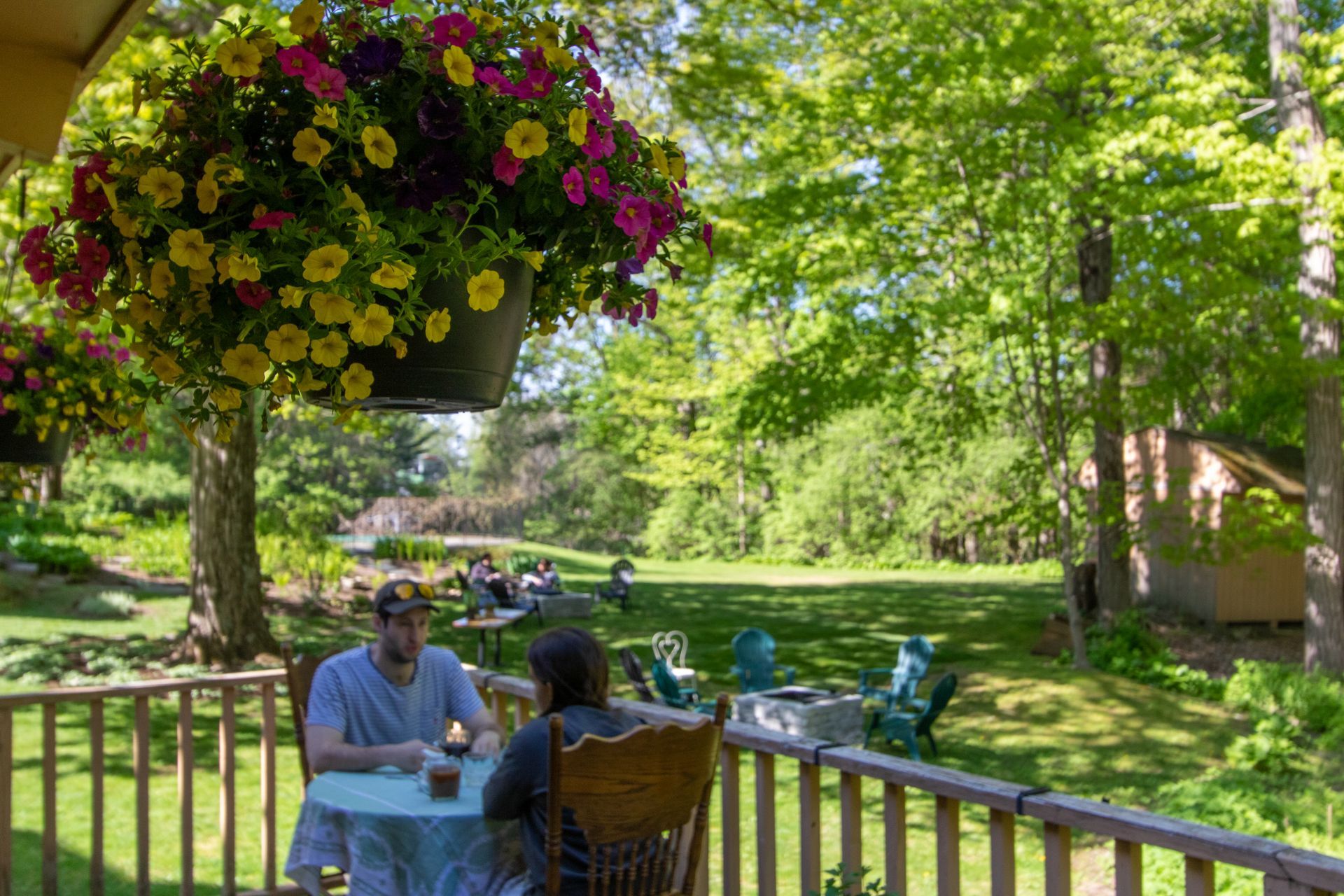 A man and a woman are sitting at a table on a porch.
