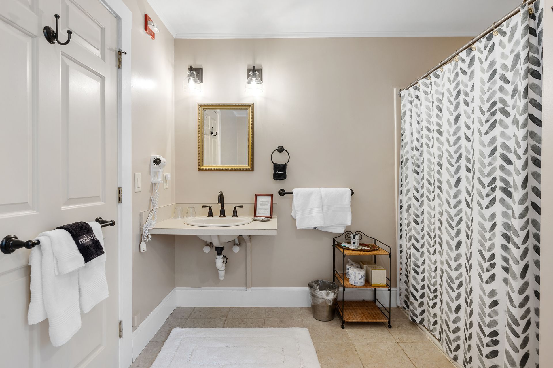 A bathroom with a sink , mirror , and shower curtain.