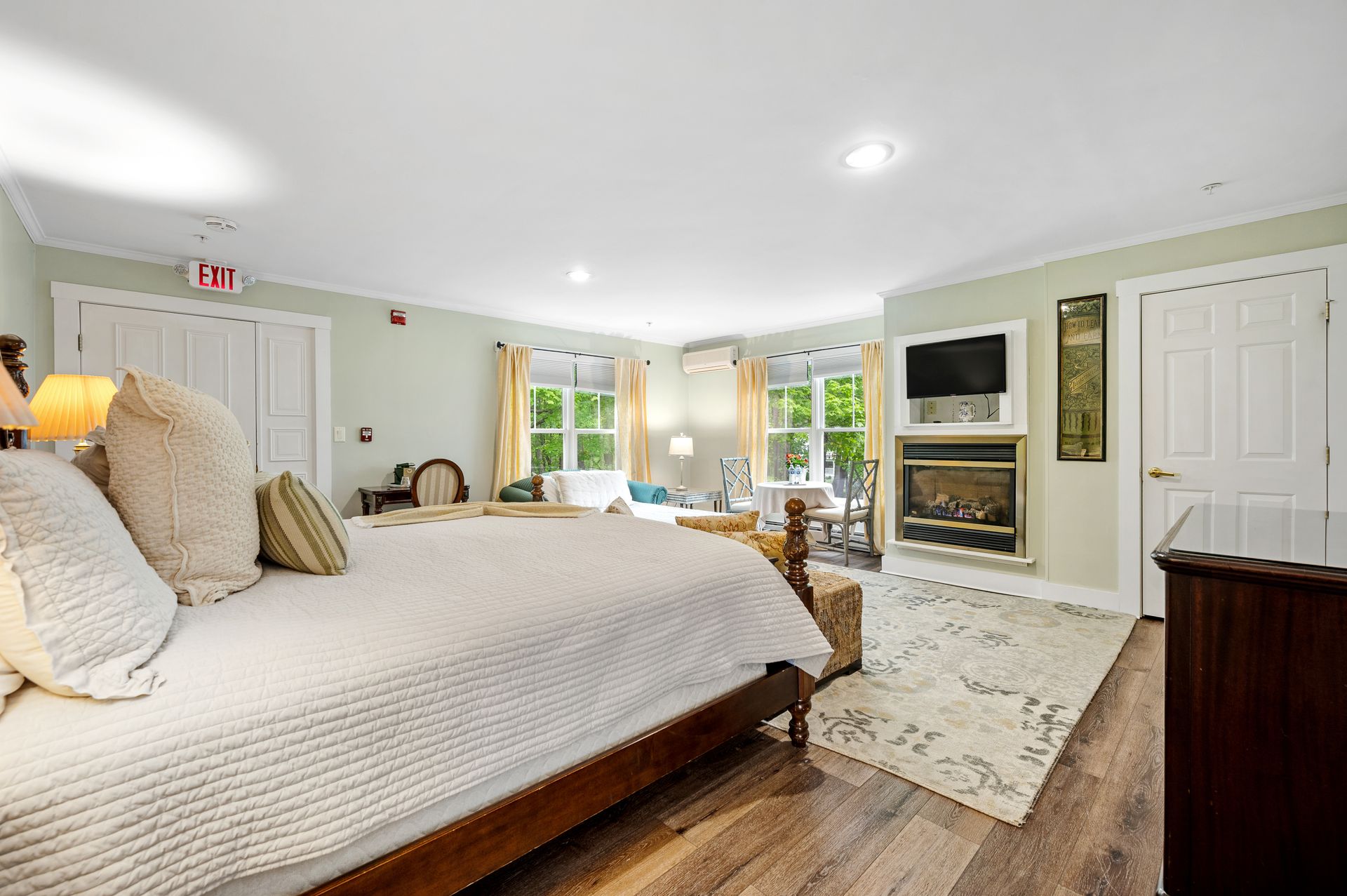 A bedroom with a king size bed and a fireplace.