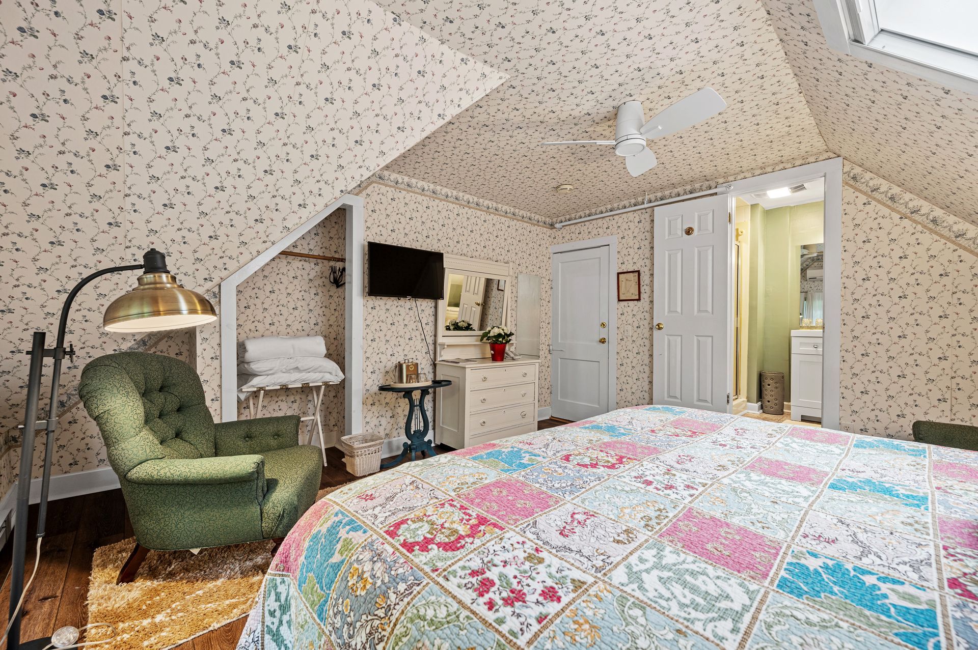 A bedroom with a bed , chair , lamp and television.