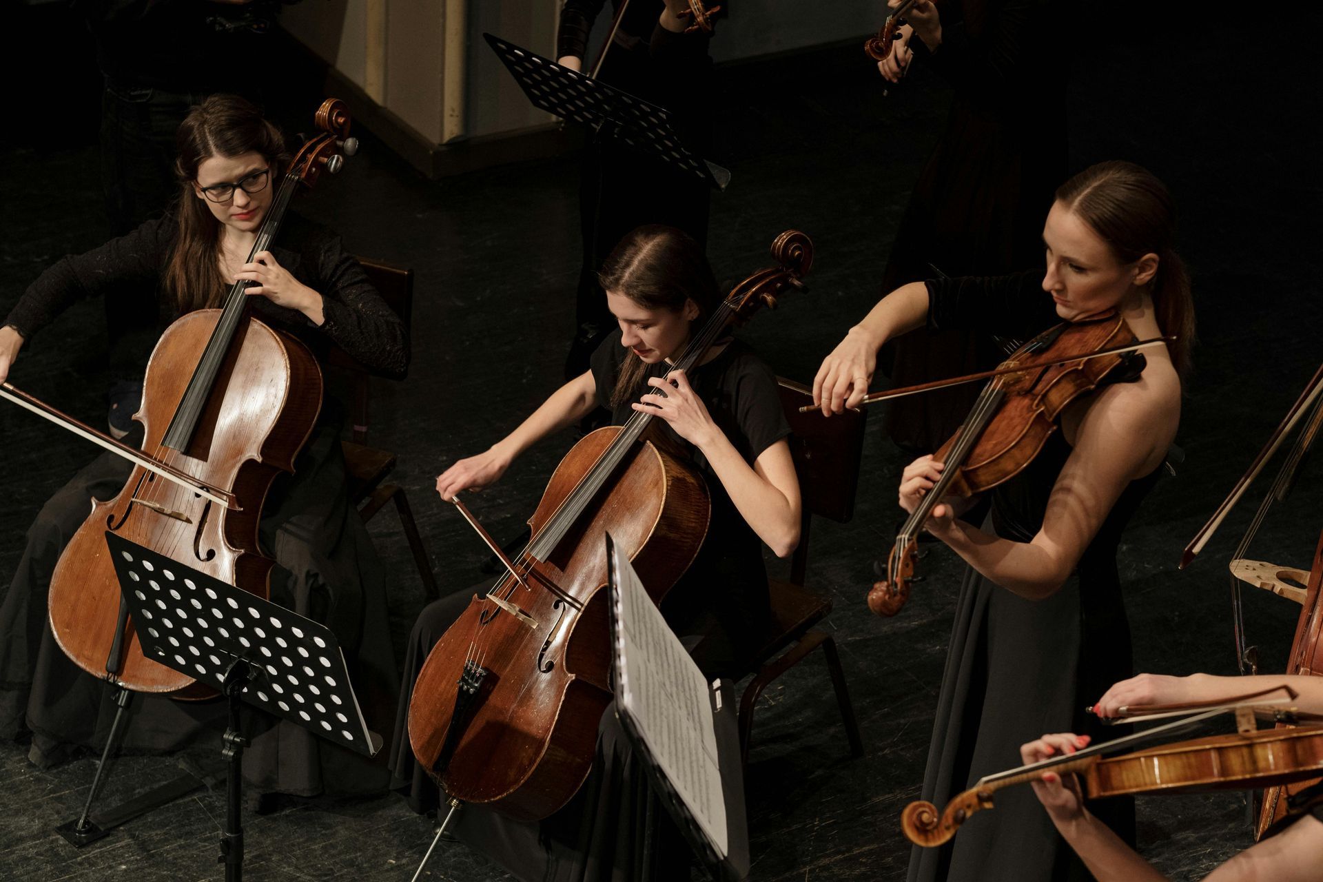 A group of women are playing violins and cello in an orchestra