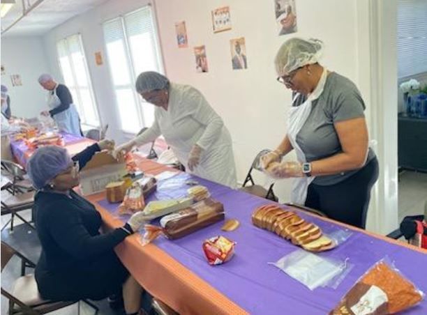 A group of women are preparing food at a table