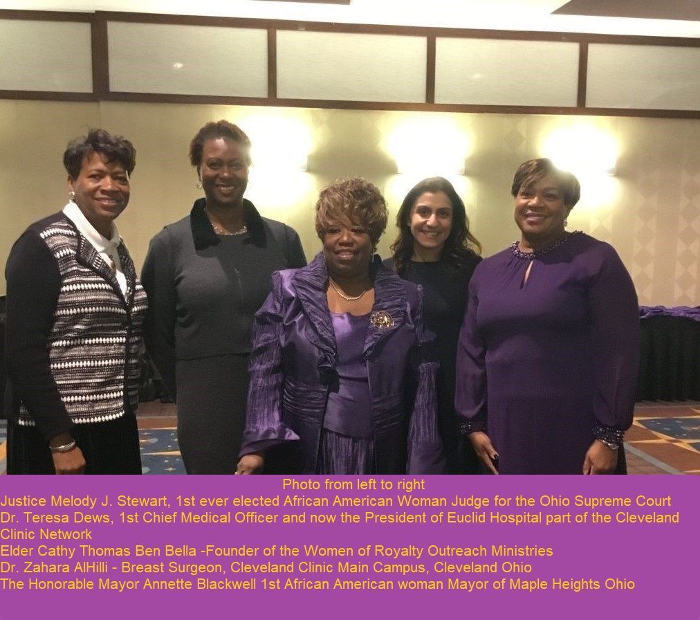 A group of women are posing for a picture and one of them is wearing a purple dress