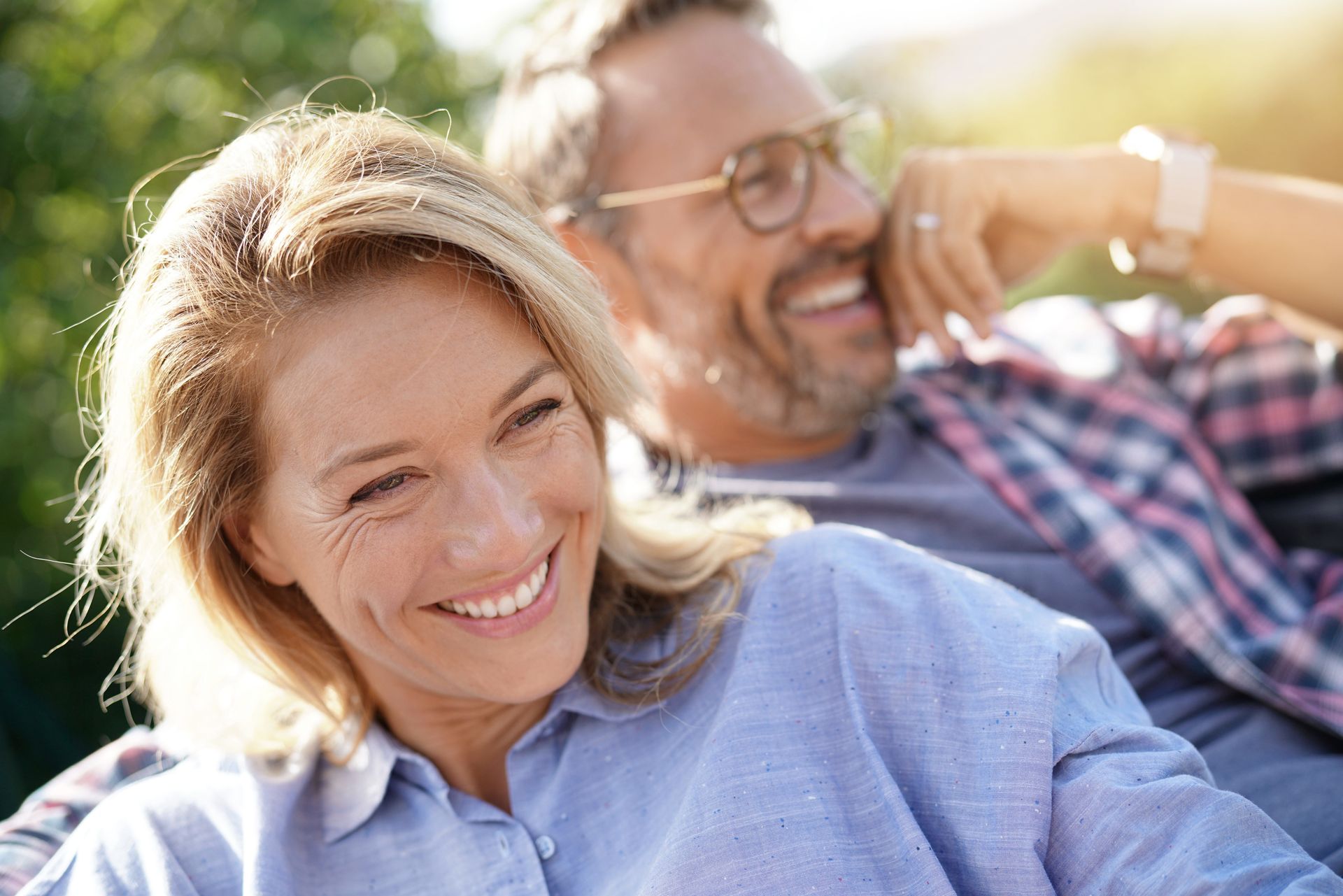 A man and a woman are sitting next to each other and smiling.