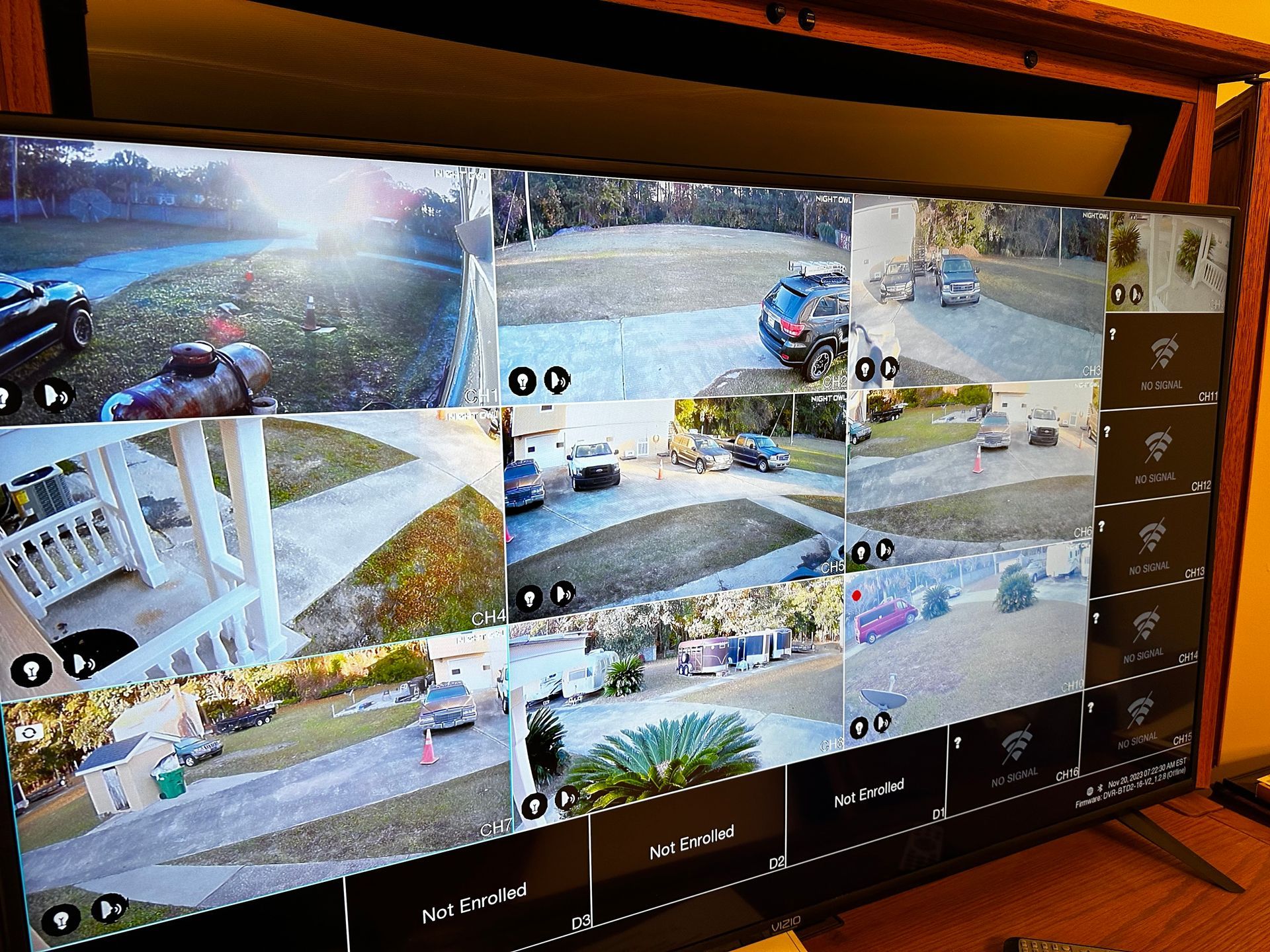 A large screen displays multiple camera views of a driveway, yard, and road, likely for security monitoring.