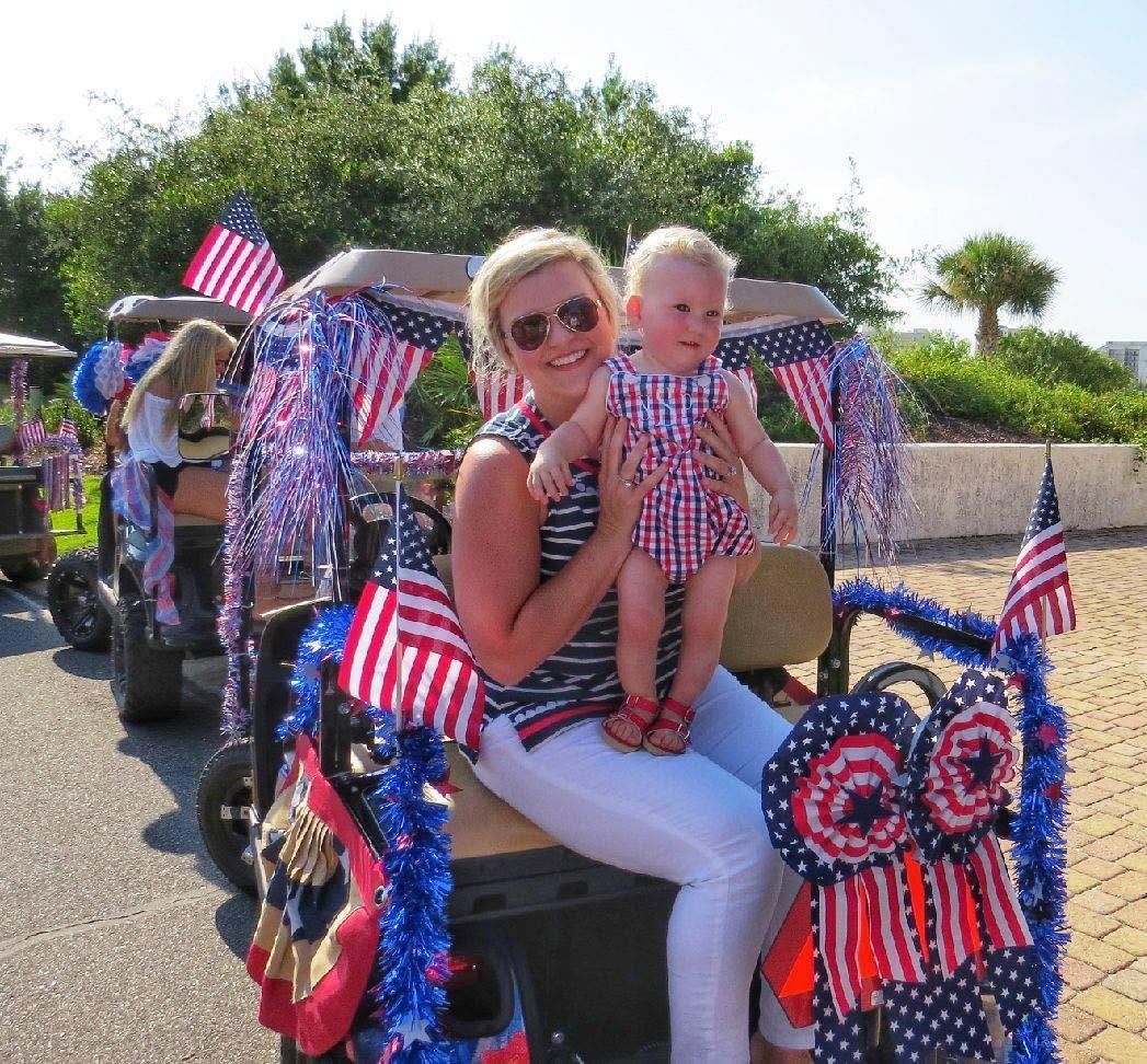 Woman and child on a decorated parade float with American flags and red, white, and blue streamers