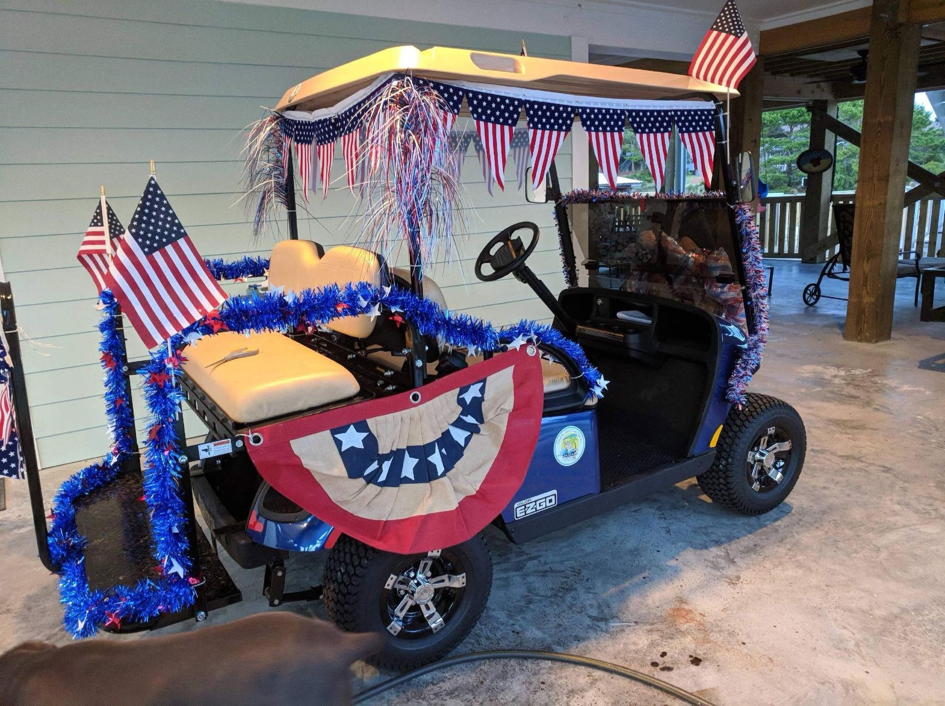 Decorated golf cart with American flags and red, white, and blue bunting at a pavilion