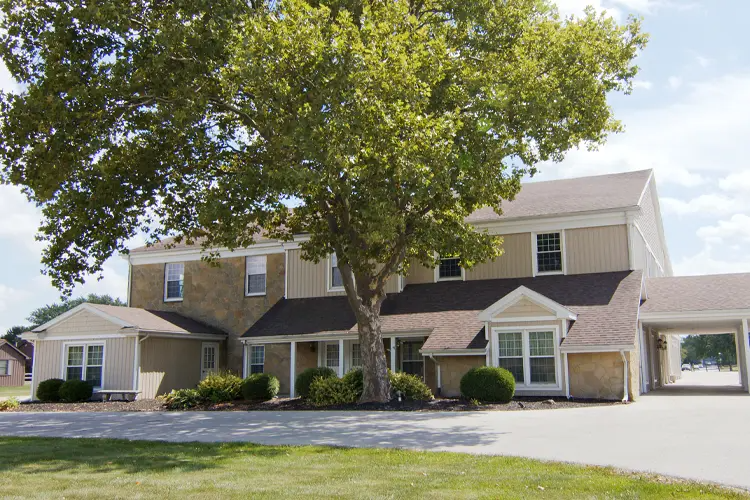 A large white building with a brown roof and a lot of windows.