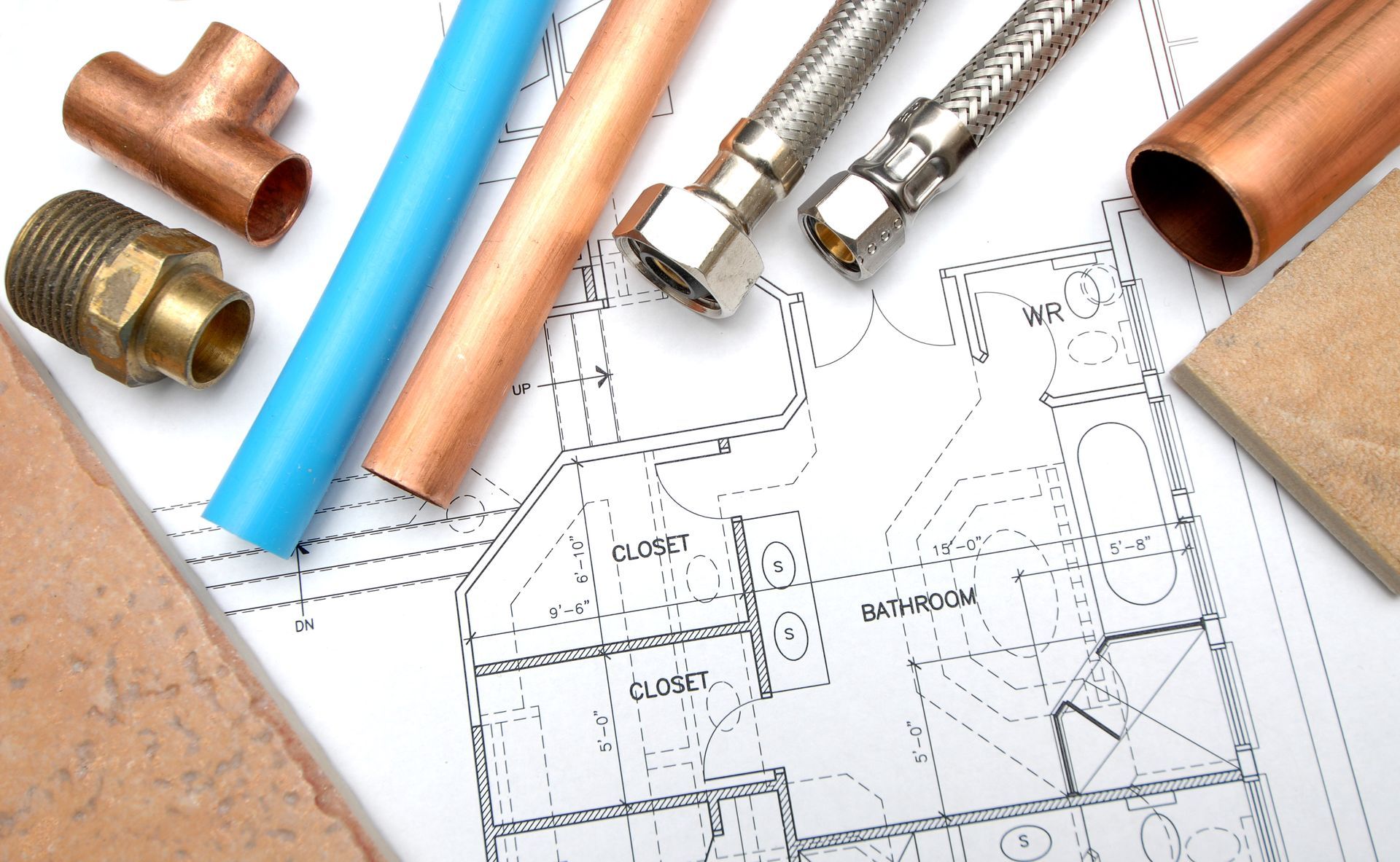 Copper pipes are laying on top of a floor plan