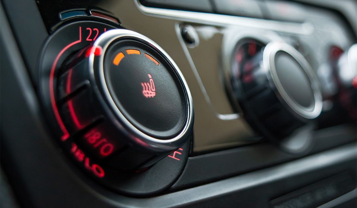 Car dashboard climate controls with illuminated temperature and fan dials in red and blue