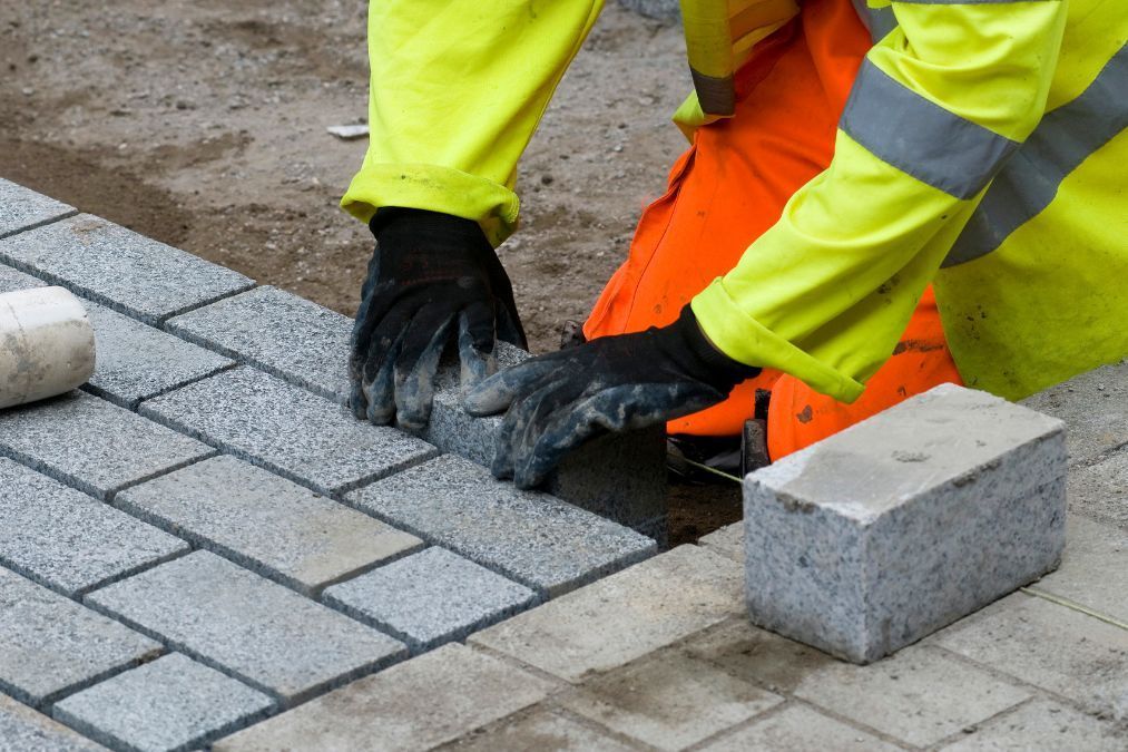 Bright grey block paving with sand underneath.