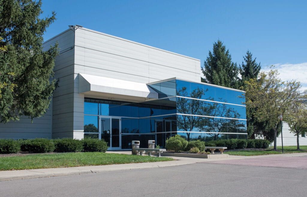 Modern Industrial Building With Blue Glass Entrance and Awning — Country Coast Valuers in Laurieton, NSW