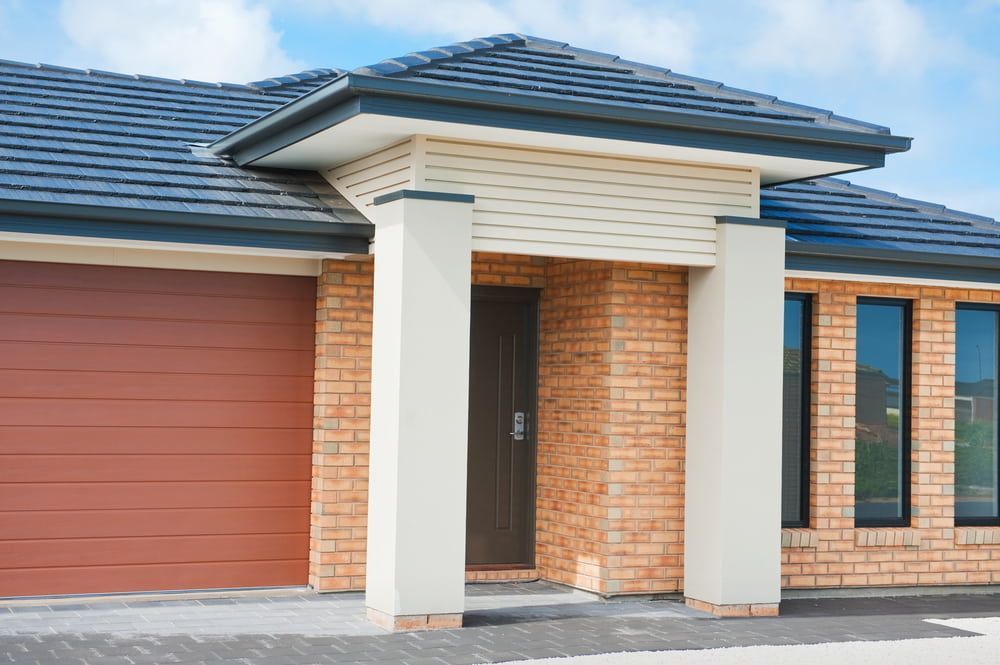 House Exterior With Brick Walls, Brown Garage Door — Country Coast Valuers in Old Bar, NSW