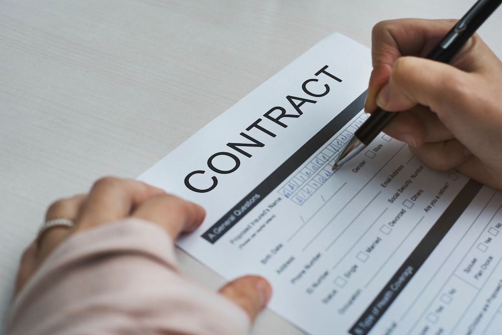Person Signing a Contract With a Pen; Document on a White Surface — Country Coast Valuers in Cundletown, NSW