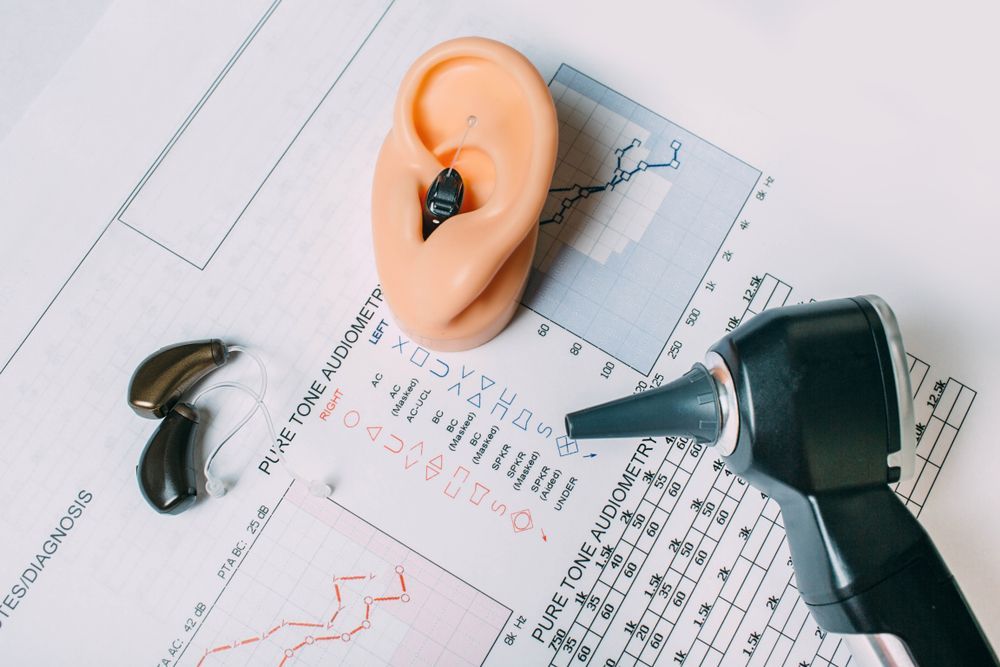 Ear model and otoscope on hearing test charts and graphs