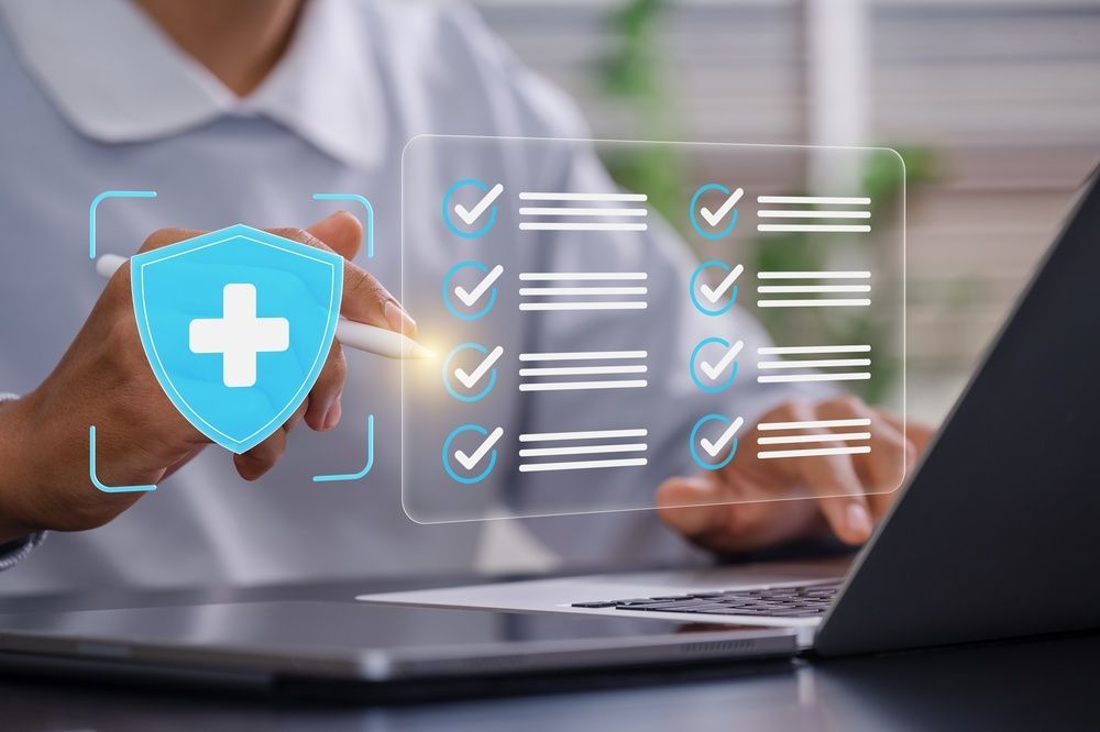 Hands typing on a laptop with a blue shield and checklist icons, suggesting online security or data protection