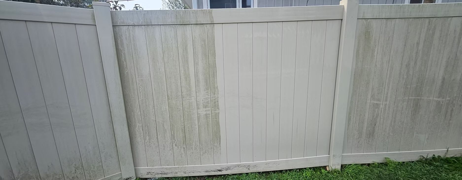 White wooden fence with a gate and green grass at the bottom