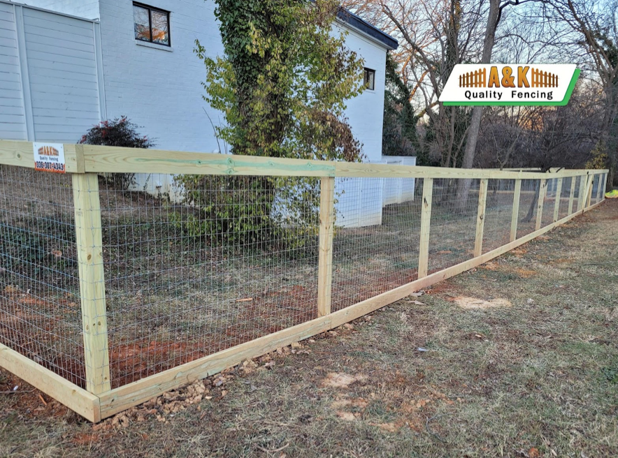 Wooden fence with wire mesh in a yard.