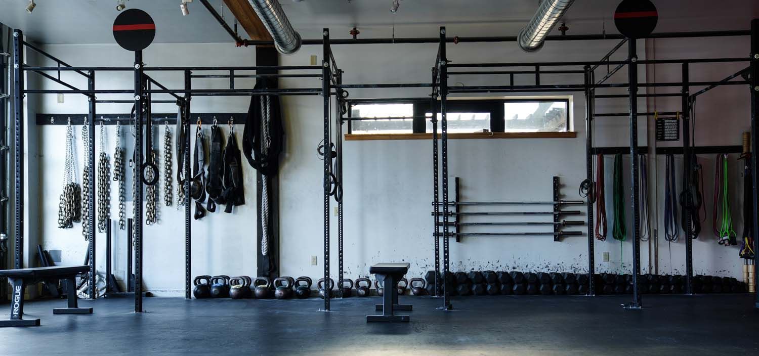 A large empty gym with a lot of equipment on the wall.