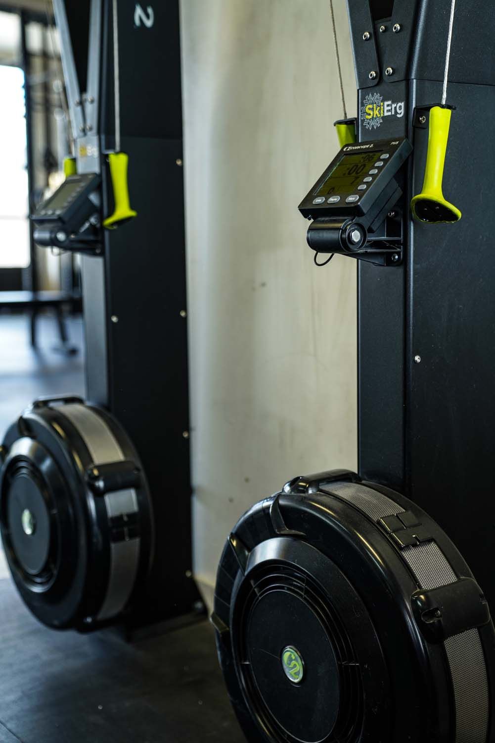 Two rowing machines are sitting next to each other in a gym