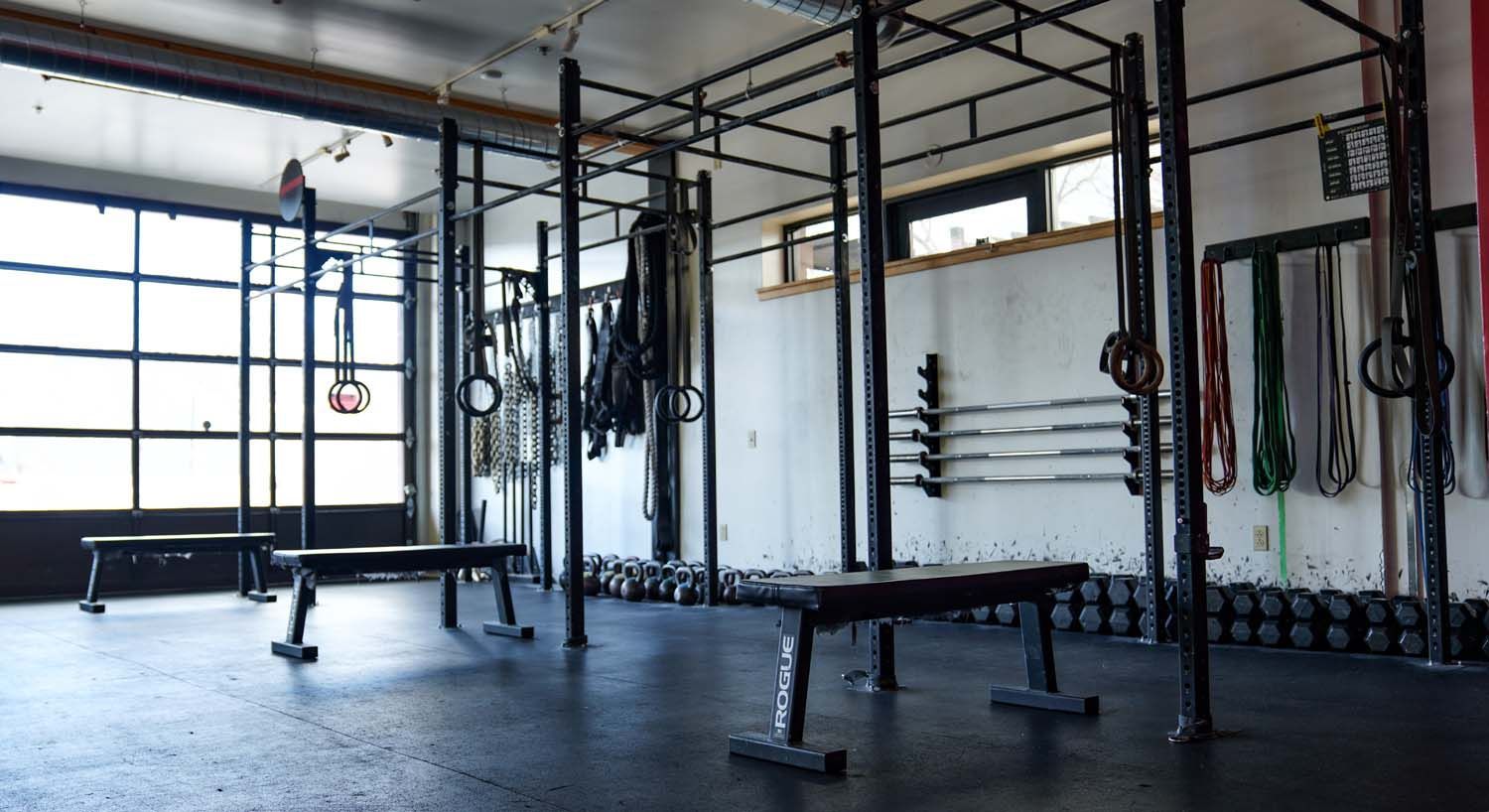 A large empty gym with a lot of equipment and benches.