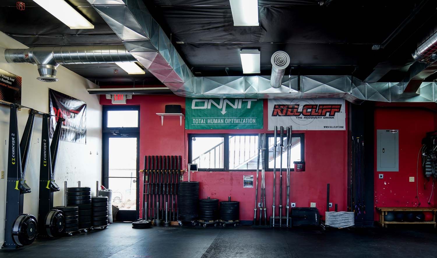 A gym with a red wall and a green sign on it.