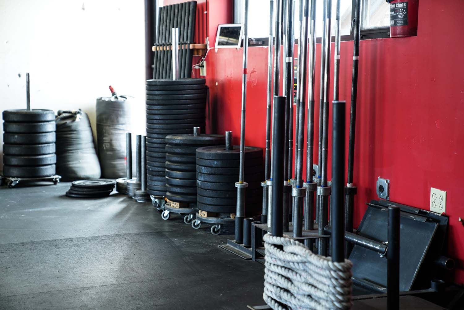 A gym filled with lots of weights and barbells.