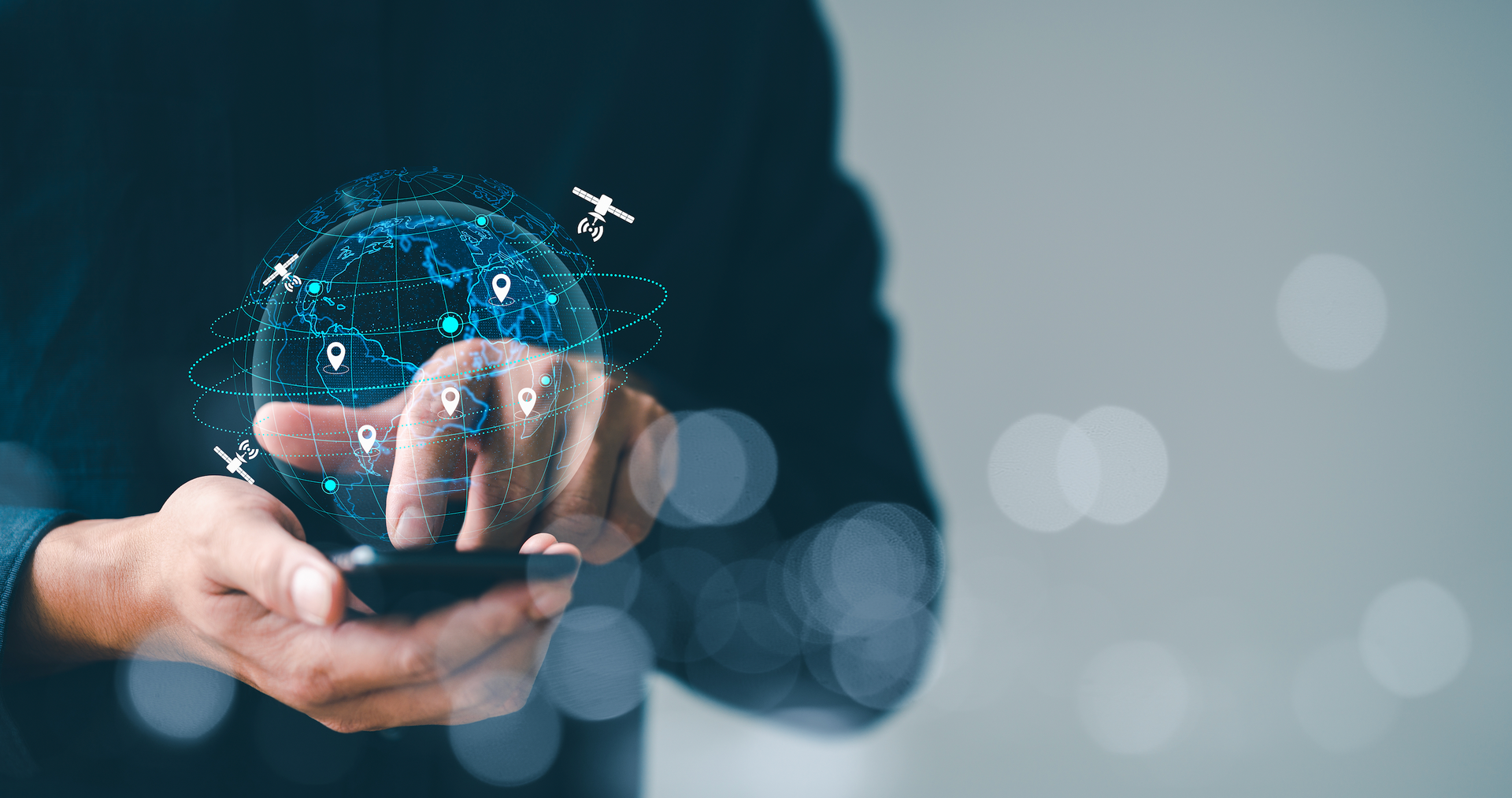 A man is holding a cell phone in his hands with a globe coming out of it.