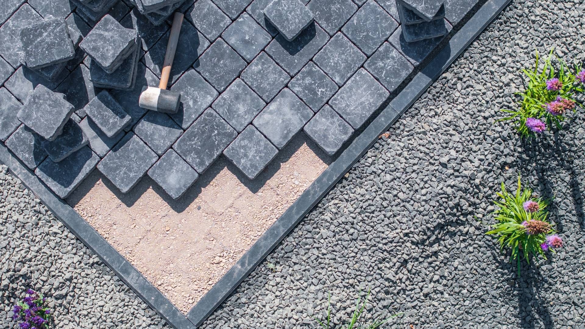 A hammer is sitting on top of a pile of bricks.