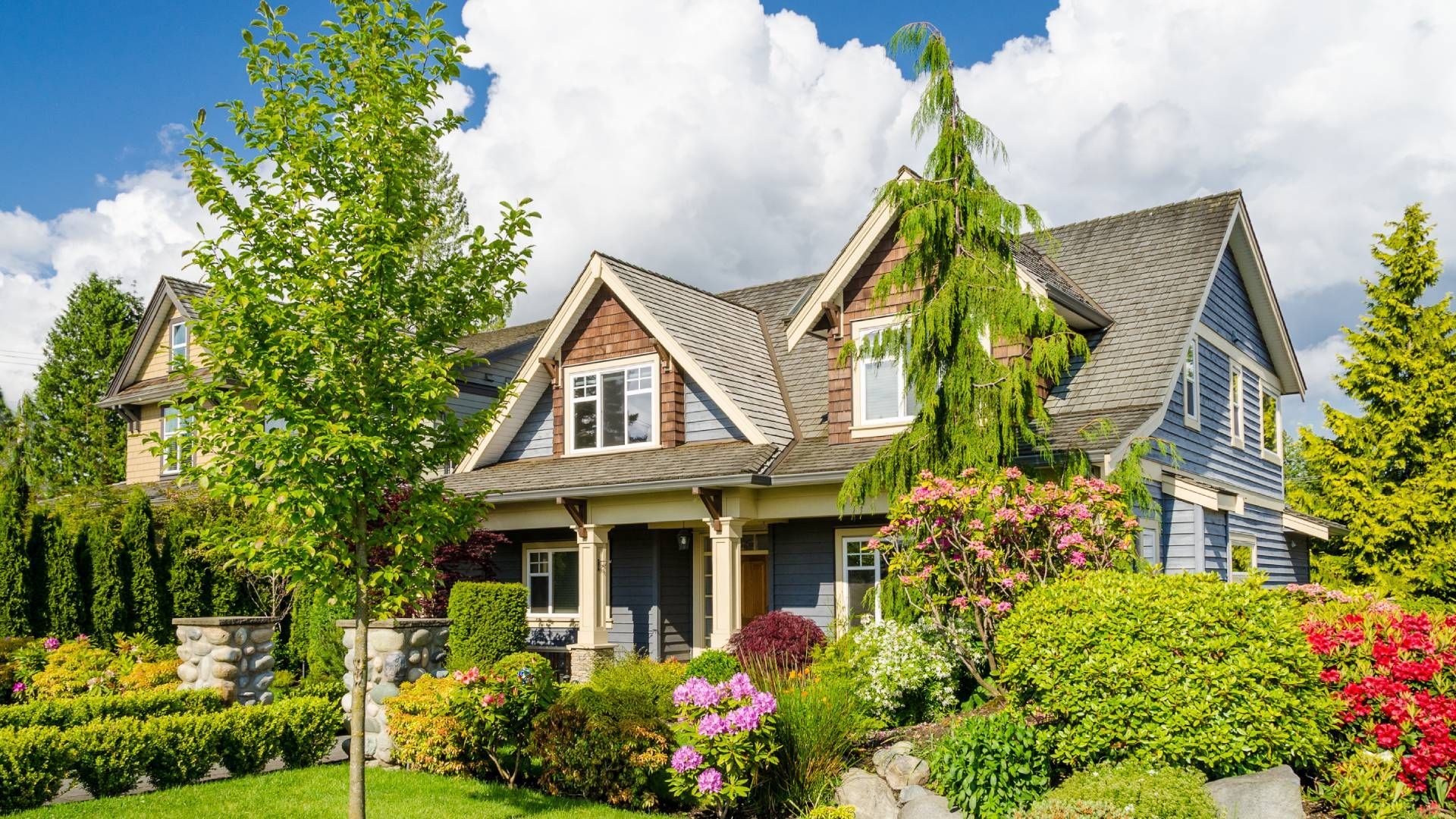 A large house with a lot of trees and bushes in front of it.