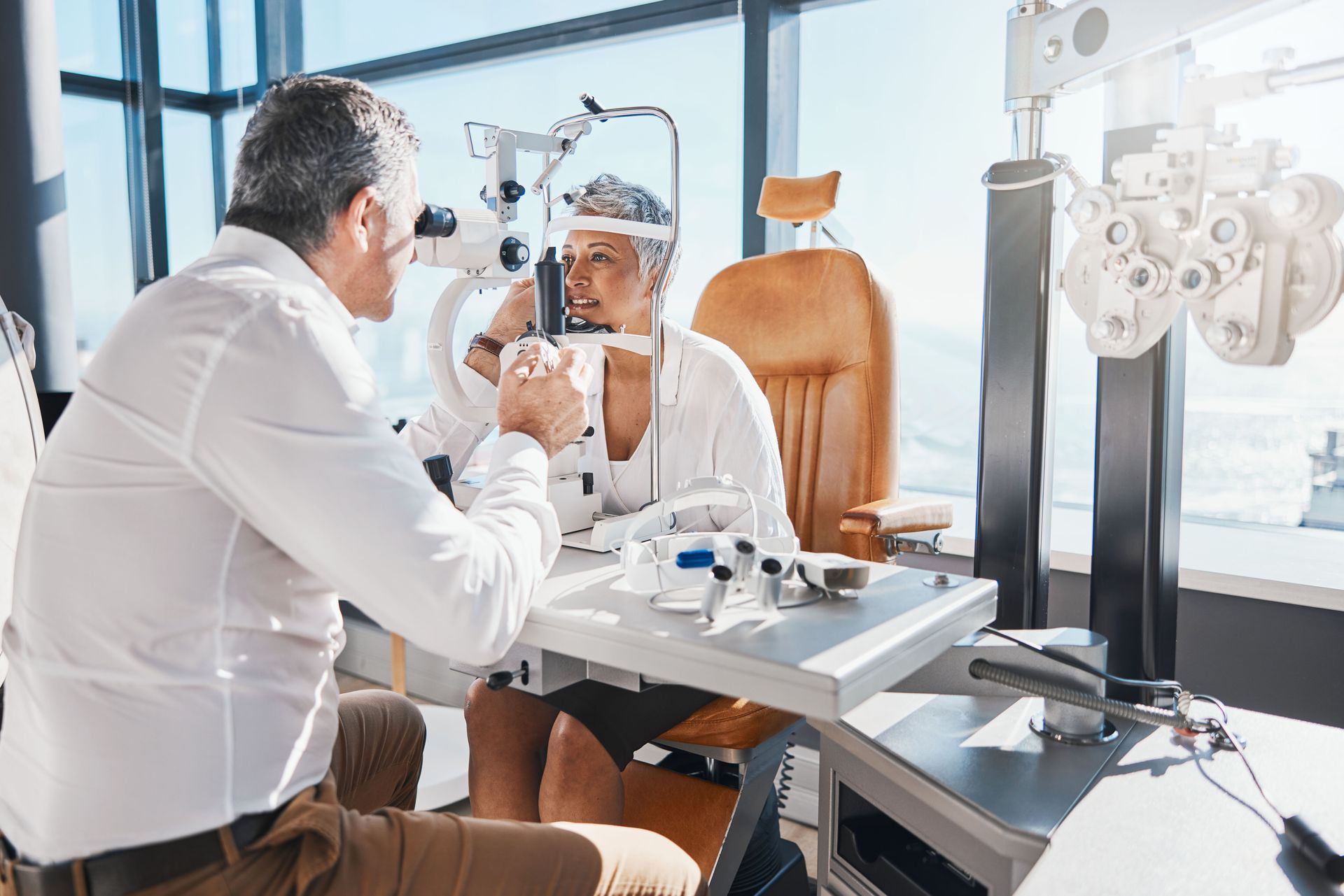 A woman is getting emergency eye care from an optometrist at an office. A woman is getting emergency eye care from an optometrist at an office.