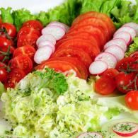 Fresh salad with lettuce, tomatoes, and sliced radishes arranged on a platter