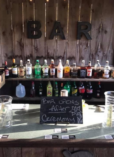 Bar counter with liquor bottles and a chalkboard sign reading “Poor Gents After Work Gentlemanly”