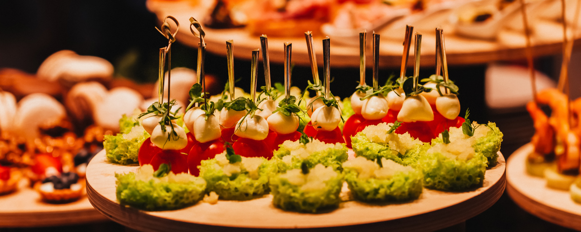 Platter of cherry tomato and herb appetizers on bread rounds at a catered buffet