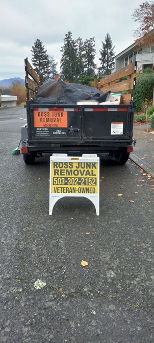 A trailer filled with junk, with a sign for