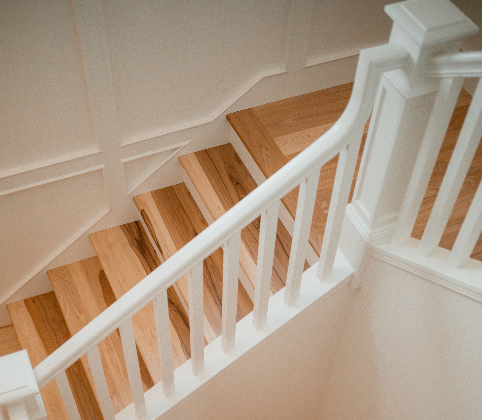 A staircase with wooden steps and a white railing