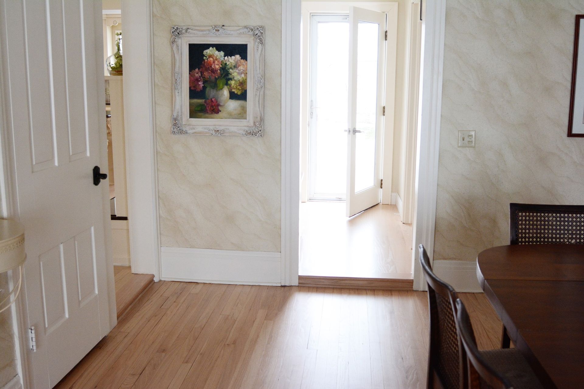 A hallway with a picture of flowers on the wall