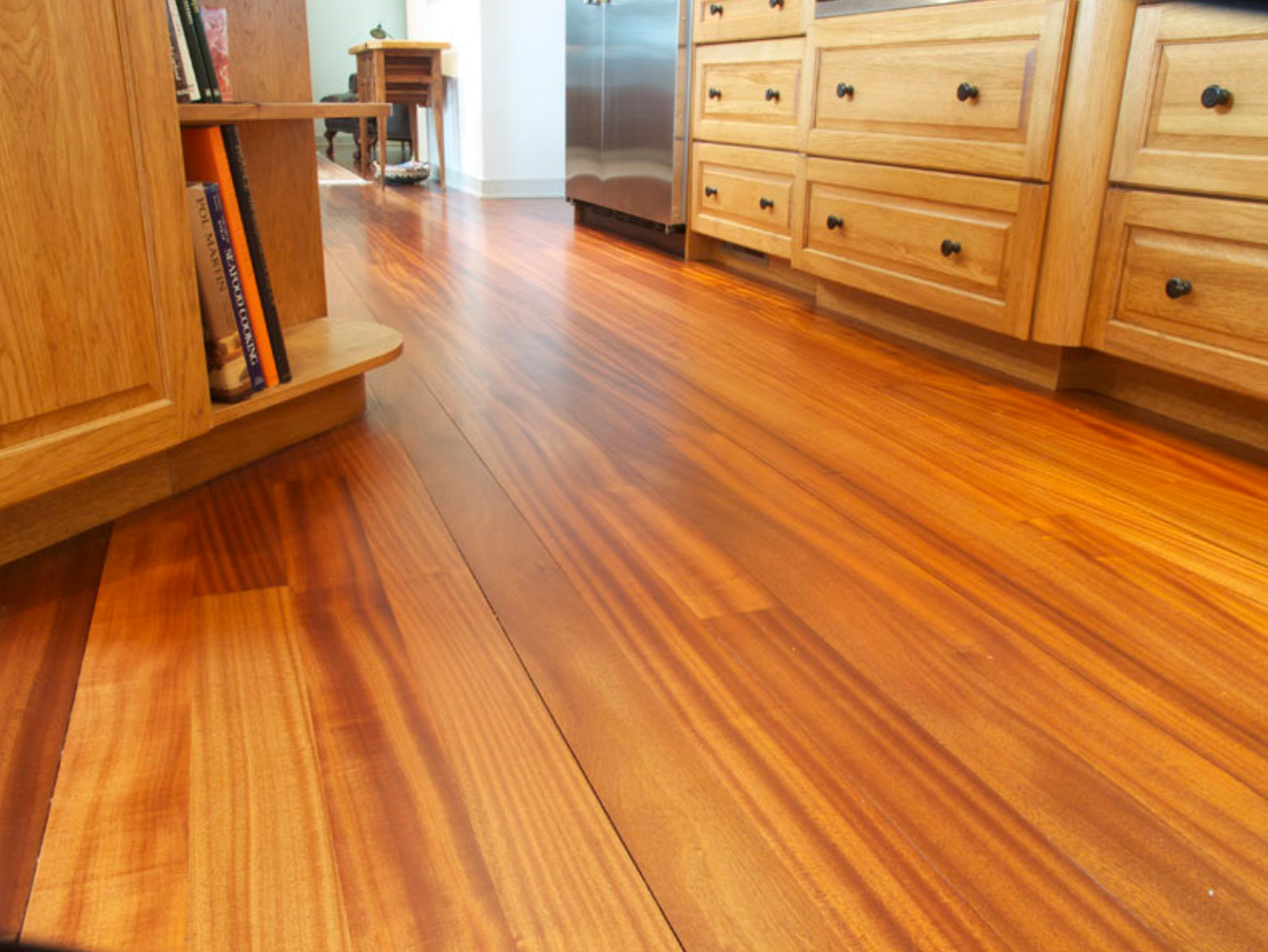A kitchen with hardwood floors and wooden cabinets