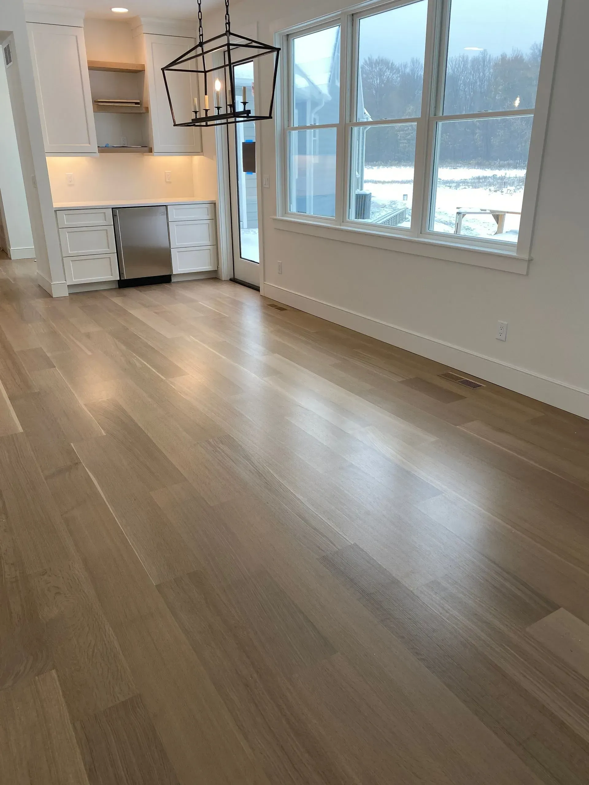 A living room with hardwood floors and lots of windows.