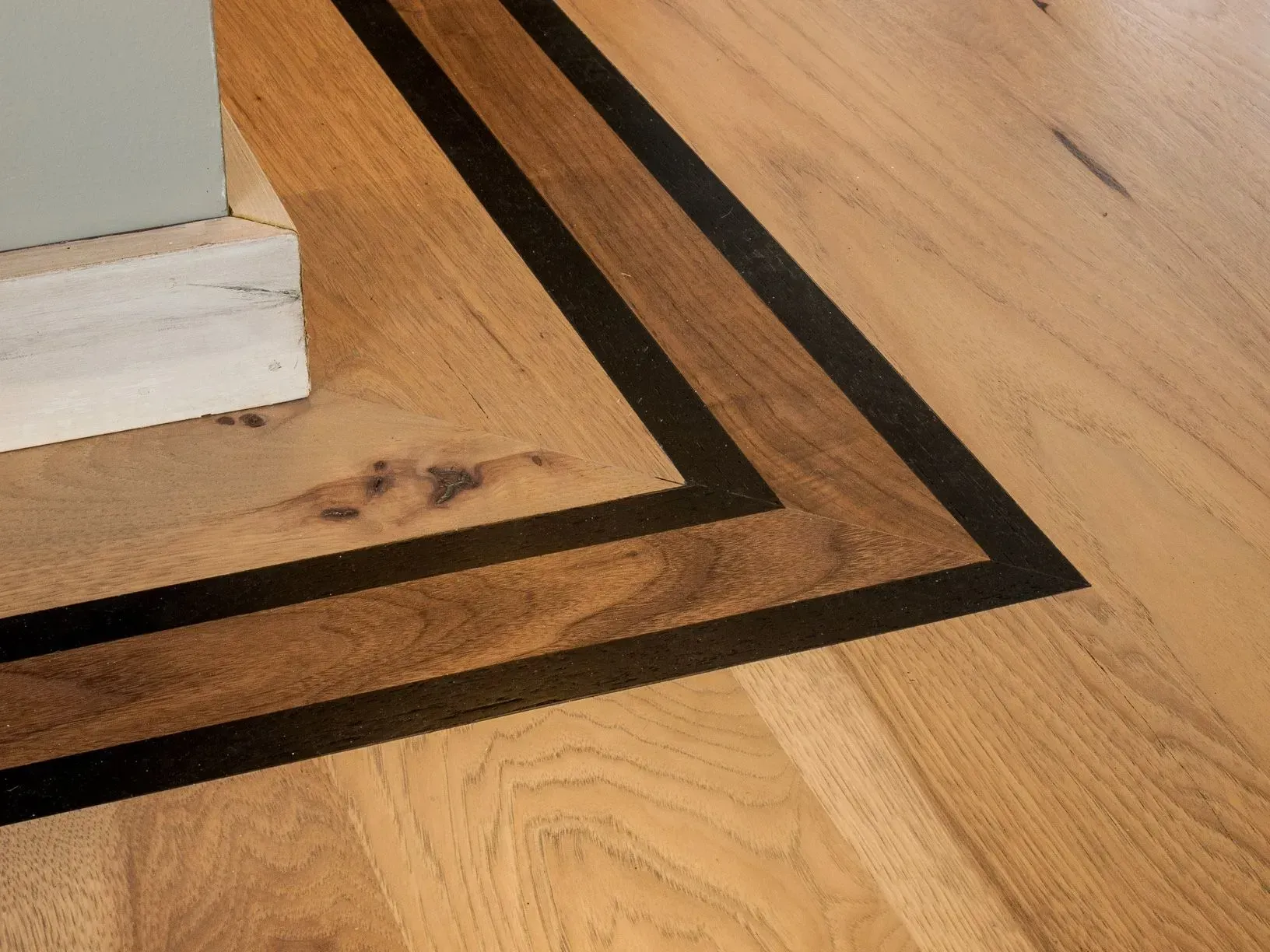A close up of a wooden floor with a black border