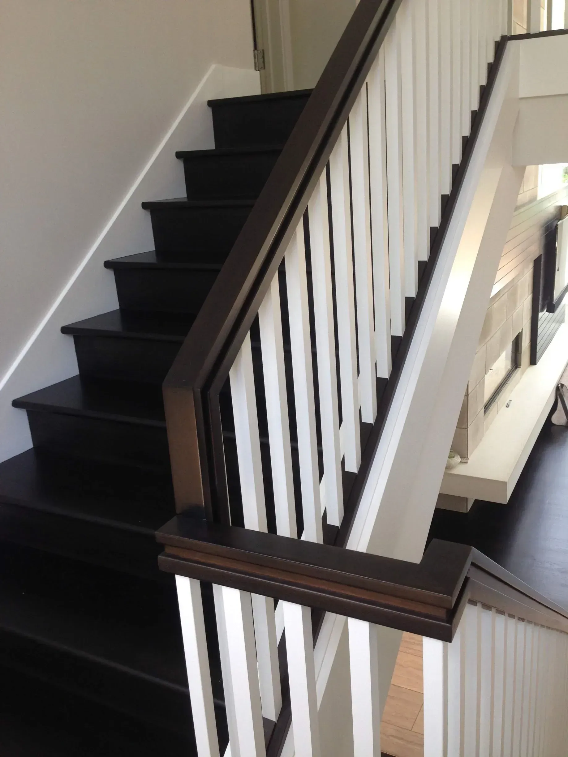 A black and white staircase with a white railing