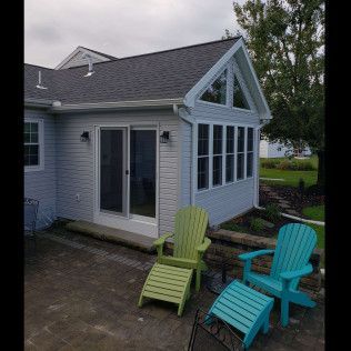 A house with a sunroom and two chairs on the patio.