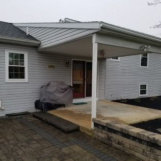 A white house with a covered porch and patio.