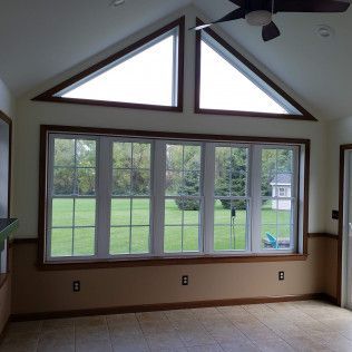 A room with a lot of windows and a ceiling fan