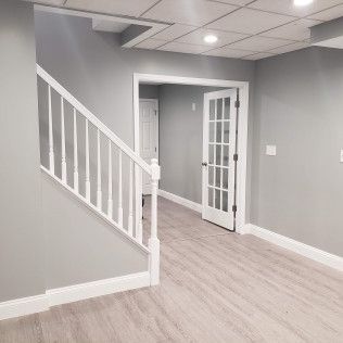 An empty basement with a staircase leading up to the second floor.