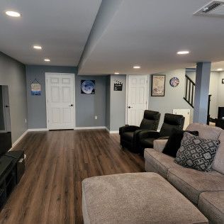 A living room with a couch , chairs , and ottoman.